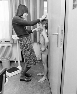 858385 Afbeelding van het meten van de lengte van een schoolkind in de wijkpost van de GG & GD (Amazonedreef 43) te Utrecht.